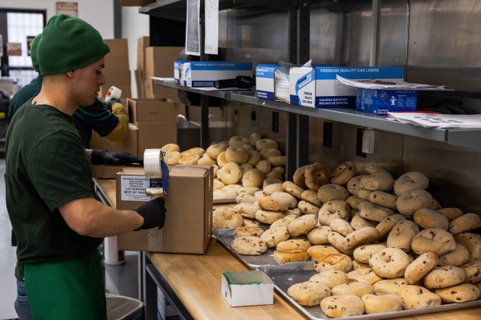 an ess-a-bagel employee with lots of bagels