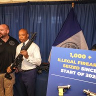 Mayor Adams with shotgun at NYPD announcement about illegal firearms seizures