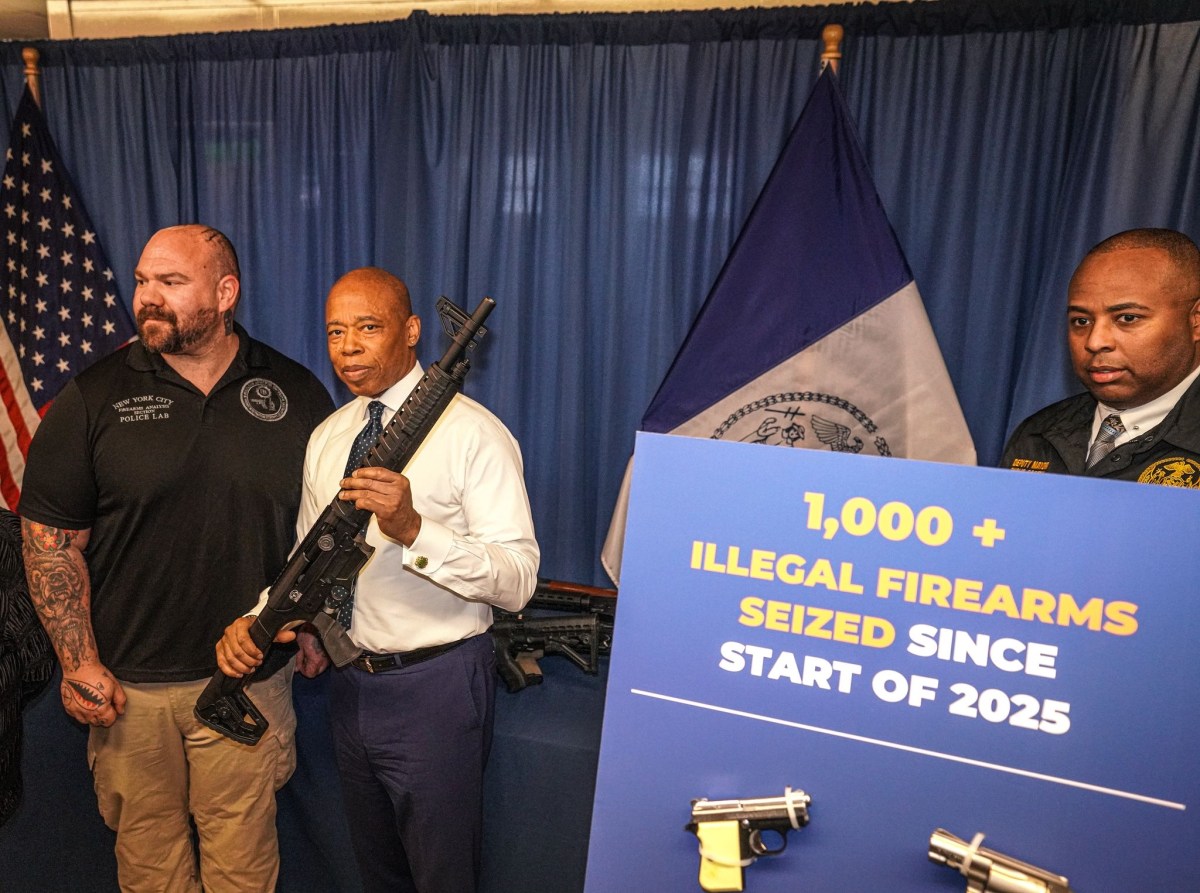 Mayor Adams with shotgun at NYPD announcement about illegal firearms seizures