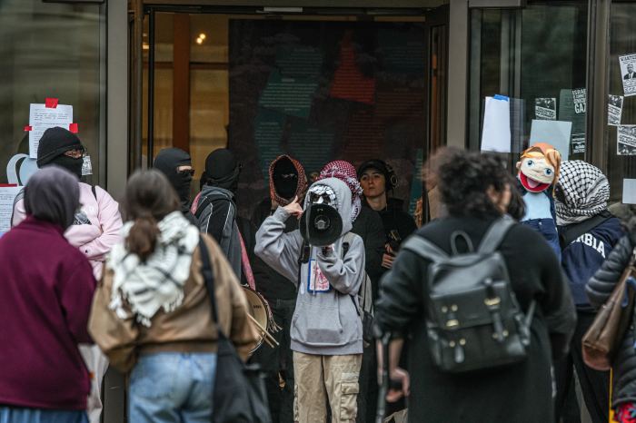 protestors at Barnard College wearing hoods and masks