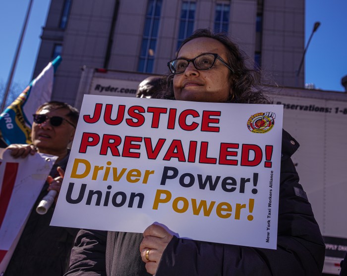 TLC driver holding a sign outside