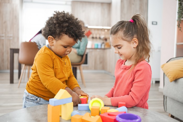 Girl and a boy enjoy a game of blocks together in the living room.