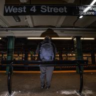 West 4th Street subway station with people leaning on metal bars