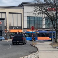 bus and cars driving the road and parking lot of the Staten Island Mall