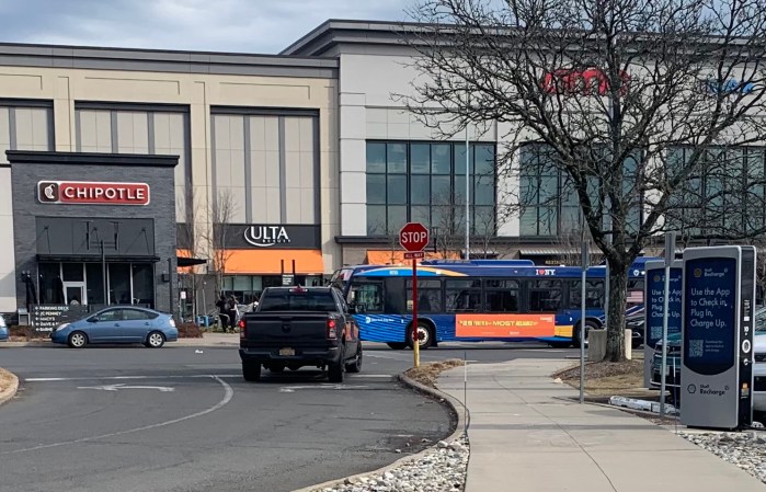 bus and cars driving the road and parking lot of the Staten Island Mall