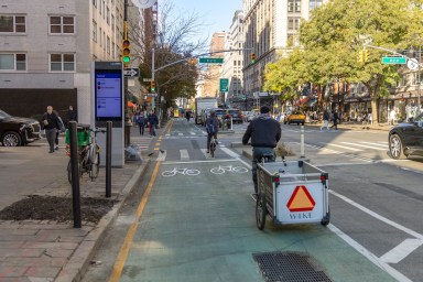 Sixth Avenue bike lane during the day with cyclists in it